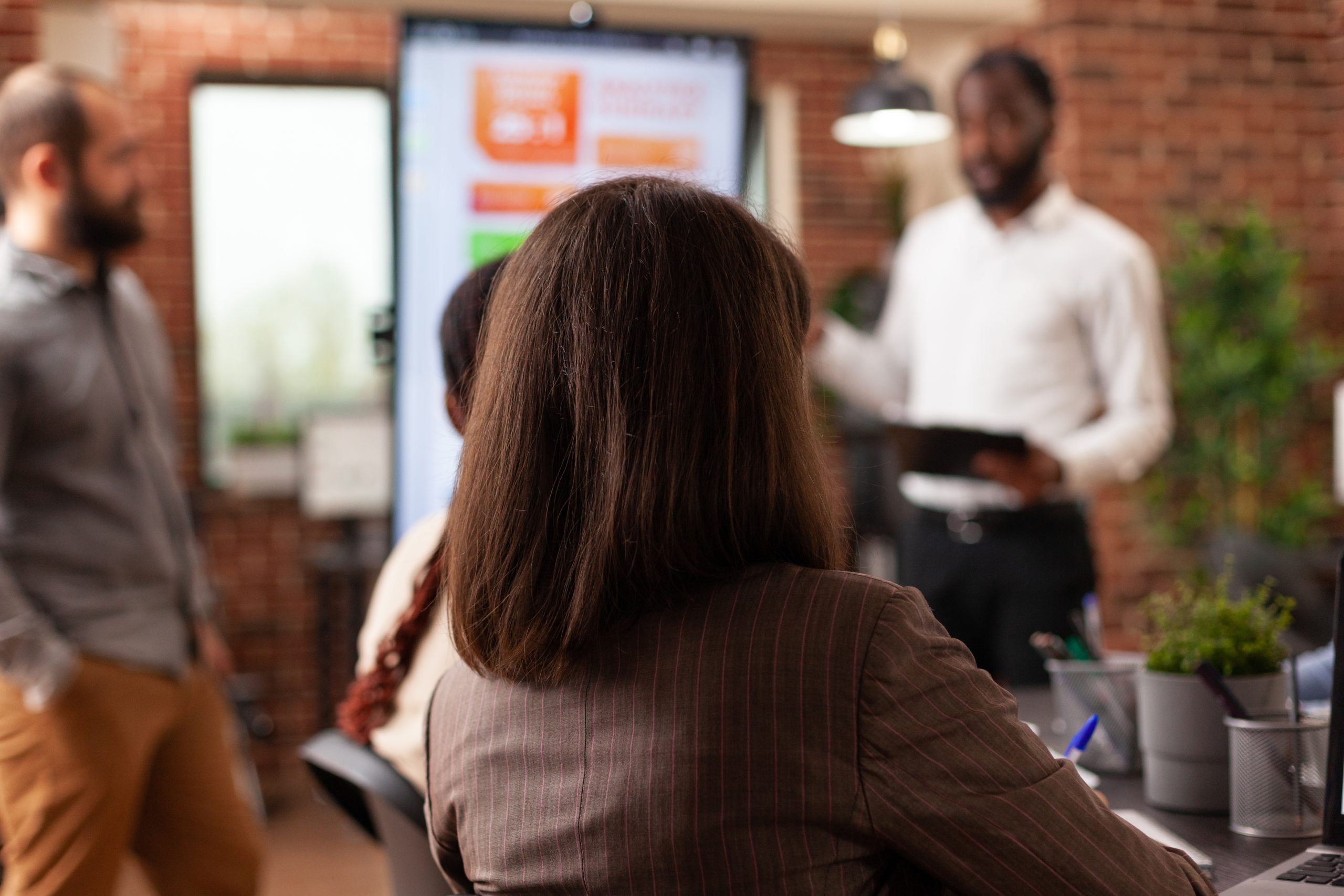 entrepreneurs sitting at meeting table in startup company office brainstorming business